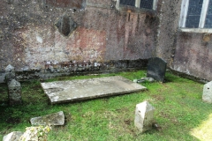 Old grave slabs beside church walls.